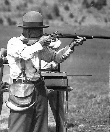This photo bridges a span of time that saw muzzle loading become a major shooting sport. Some modern-day participants adopt this style of garb when attending traditional-style shooting matches. The shooter in the photo is identified as Elmore Light.