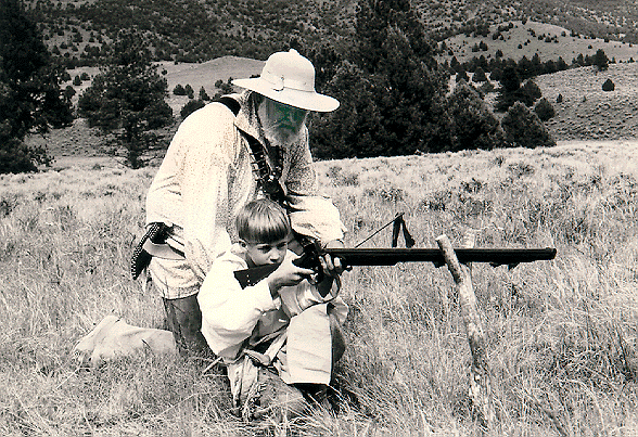 Dale Nelson coaches his grandson Danny while the boy shoots a 20-gauge Trade Gun from cross-sticks